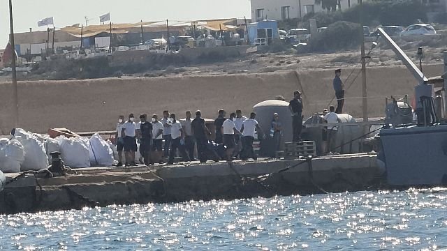 Rescuers rush to aid migrants whose boat capsized off Italy, killing 26