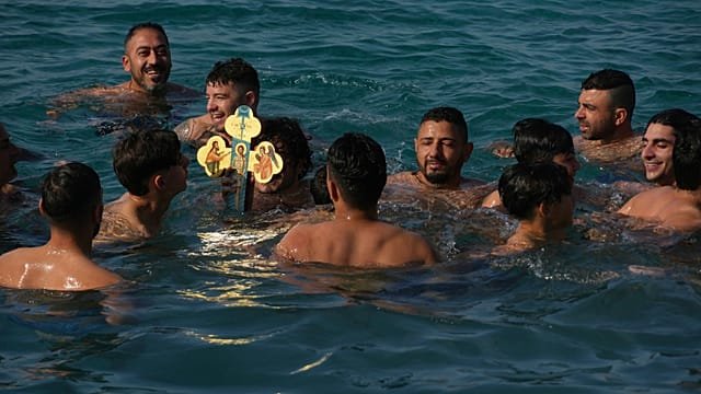 Young men in Greece dive for wooden cross in Epiphany celebration